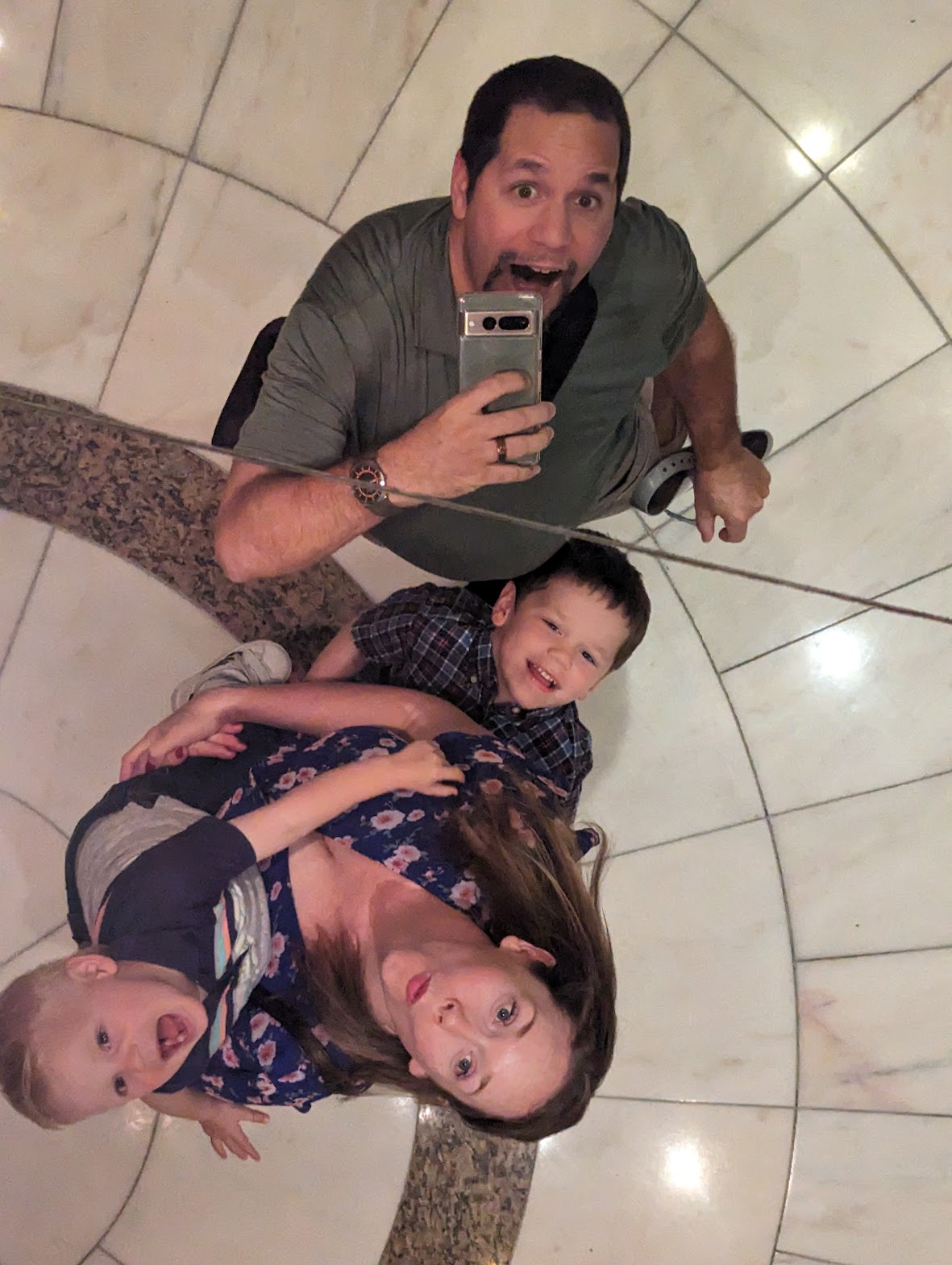 a man and woman taking a selfie with two children