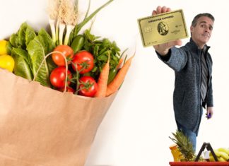 a man holding a credit card next to a bag of vegetables