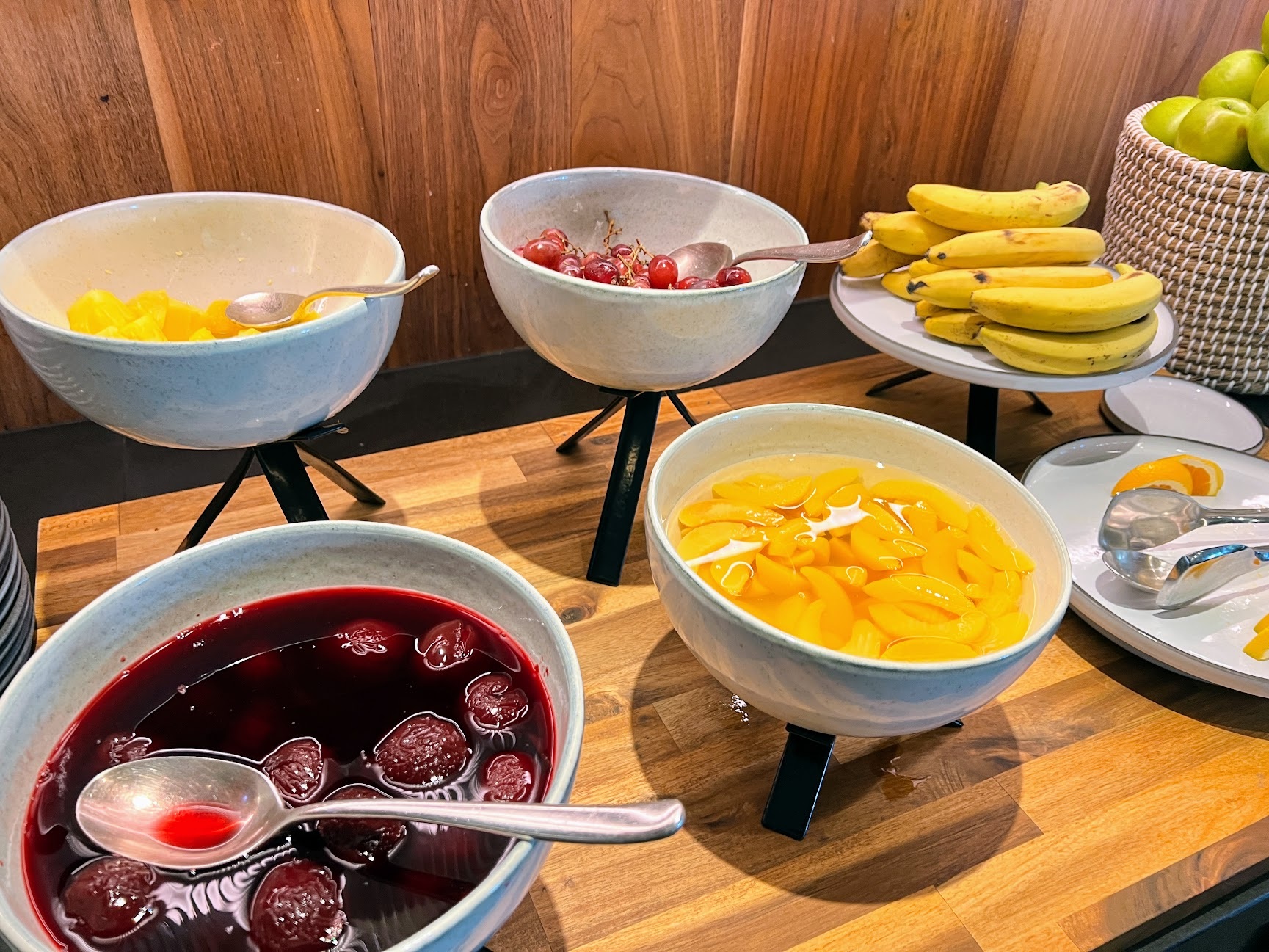 a table with bowls of fruit and bananas