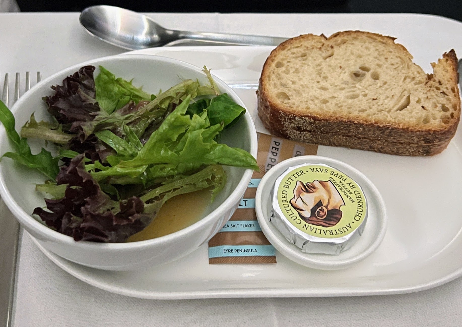 a plate with a bowl of soup and a piece of bread