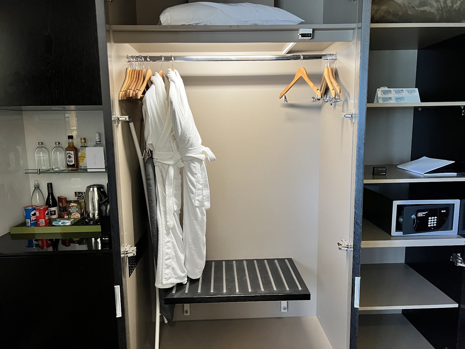 a closet with white robe on a rack