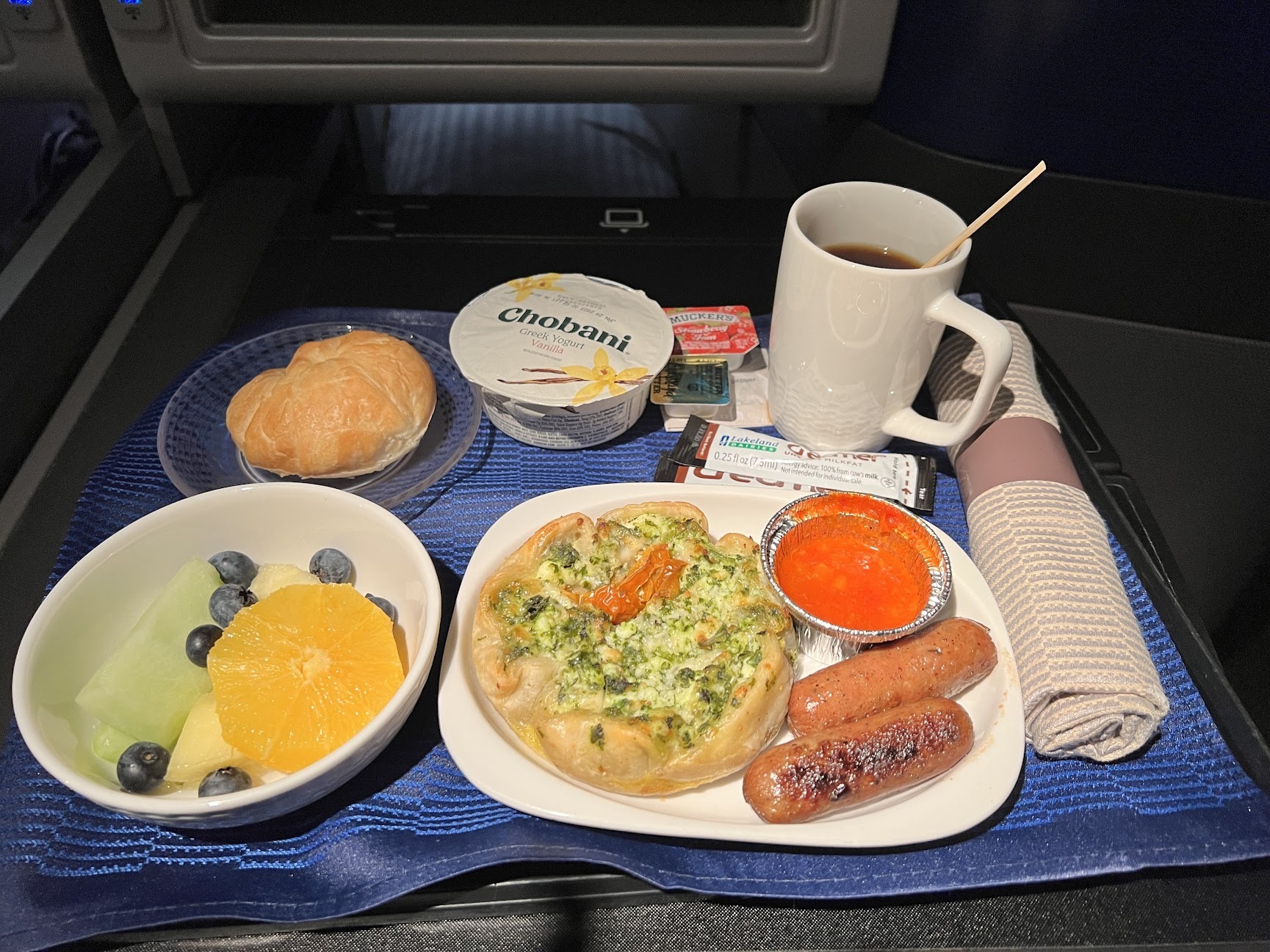 a tray of food and coffee on a blue surface