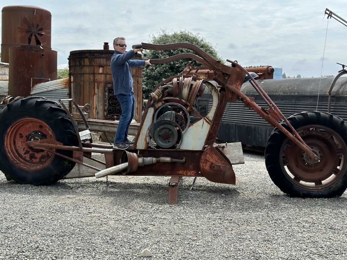 a man standing on a large rusty tractor