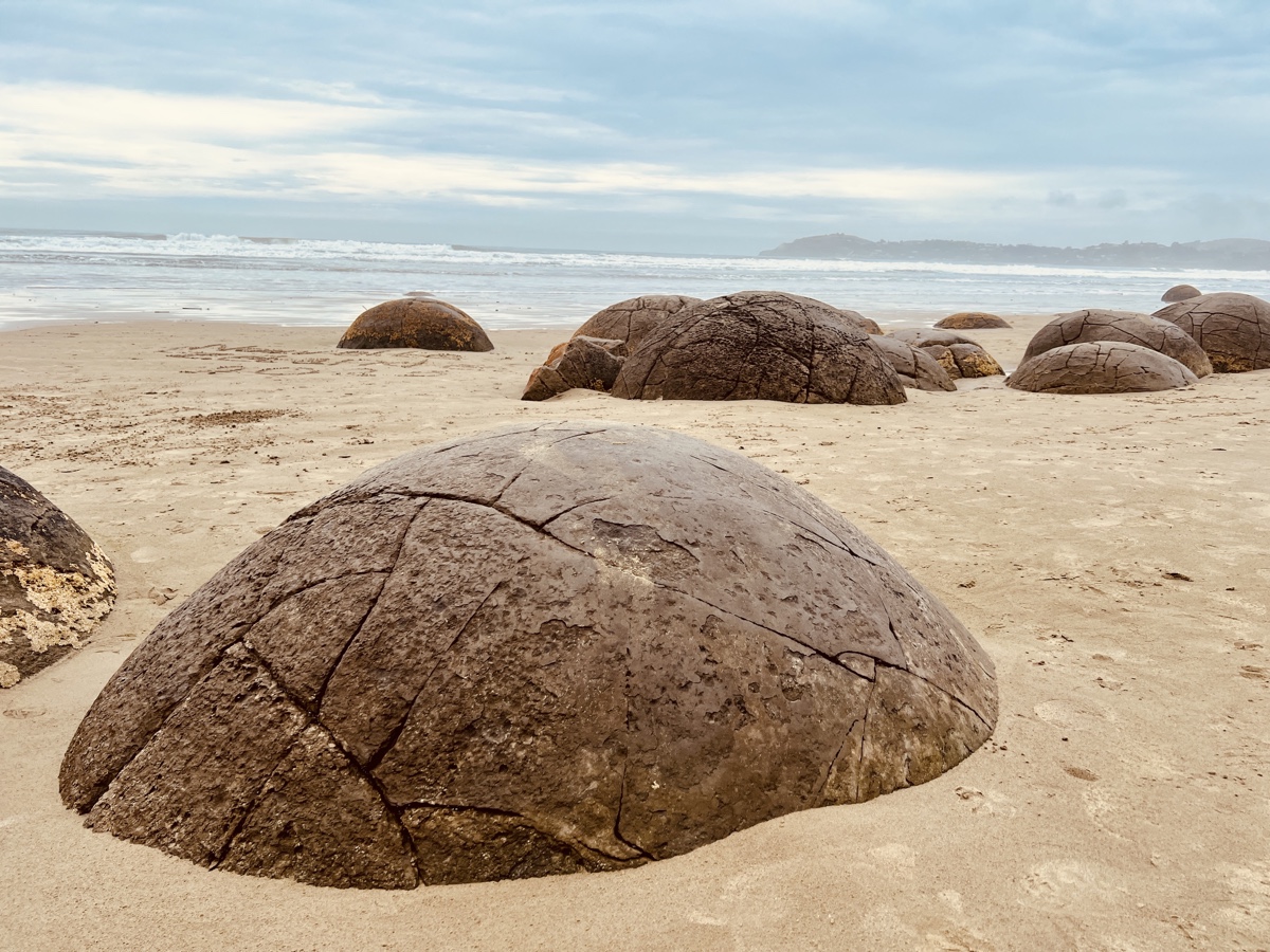 a group of round rocks on a beach