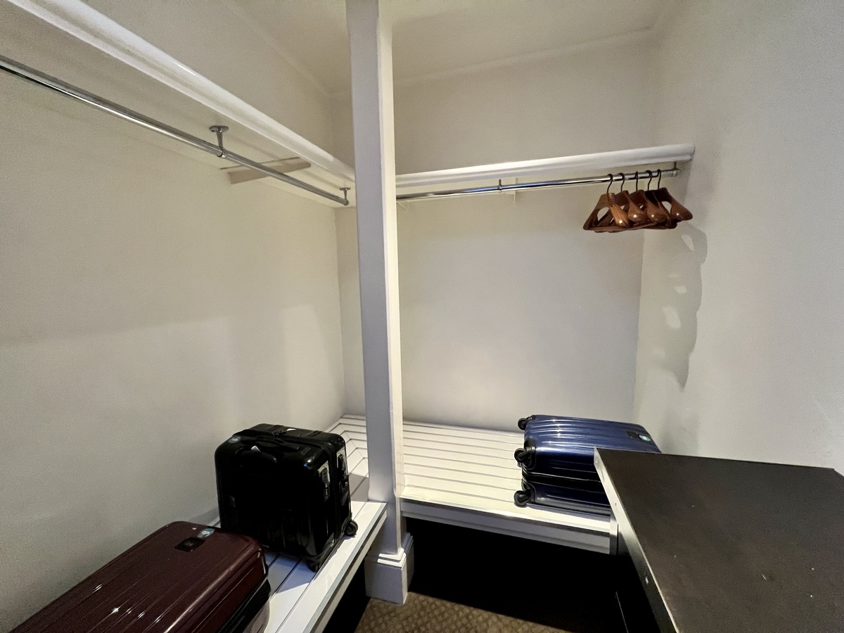 a closet with luggage on shelves