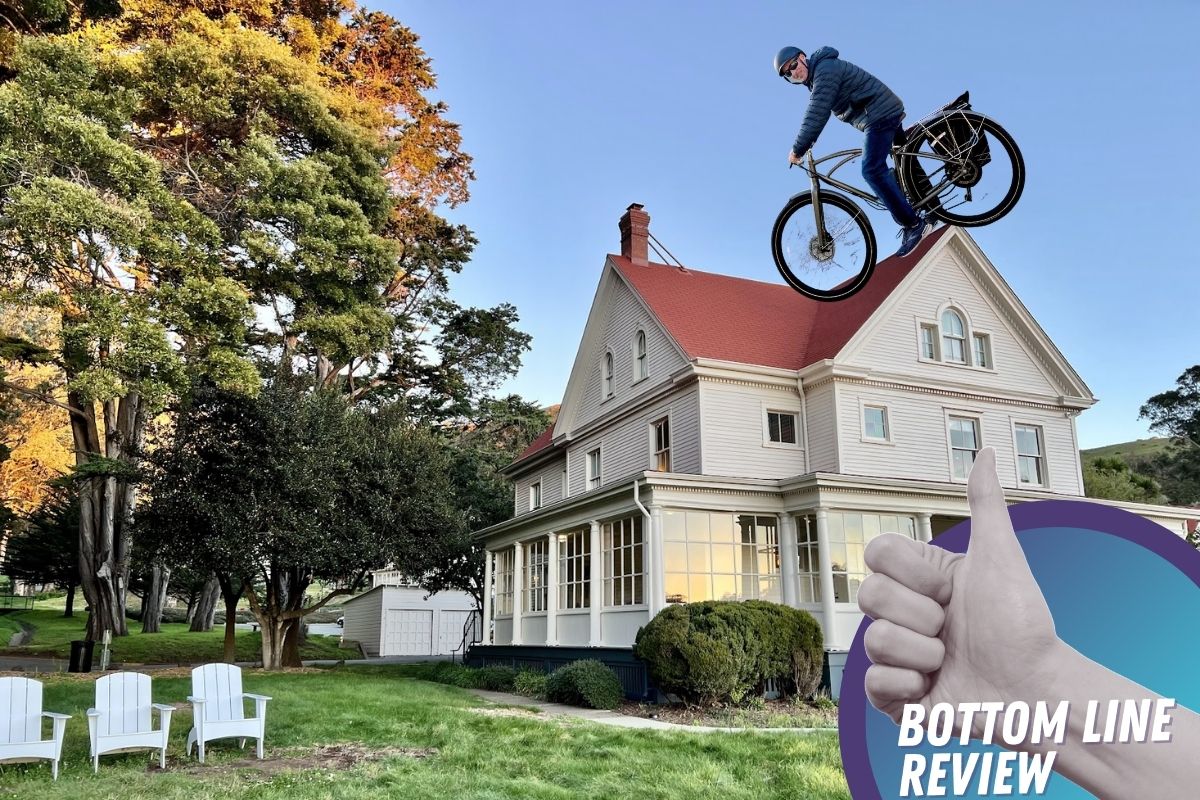a man riding a bicycle in the air in front of a house