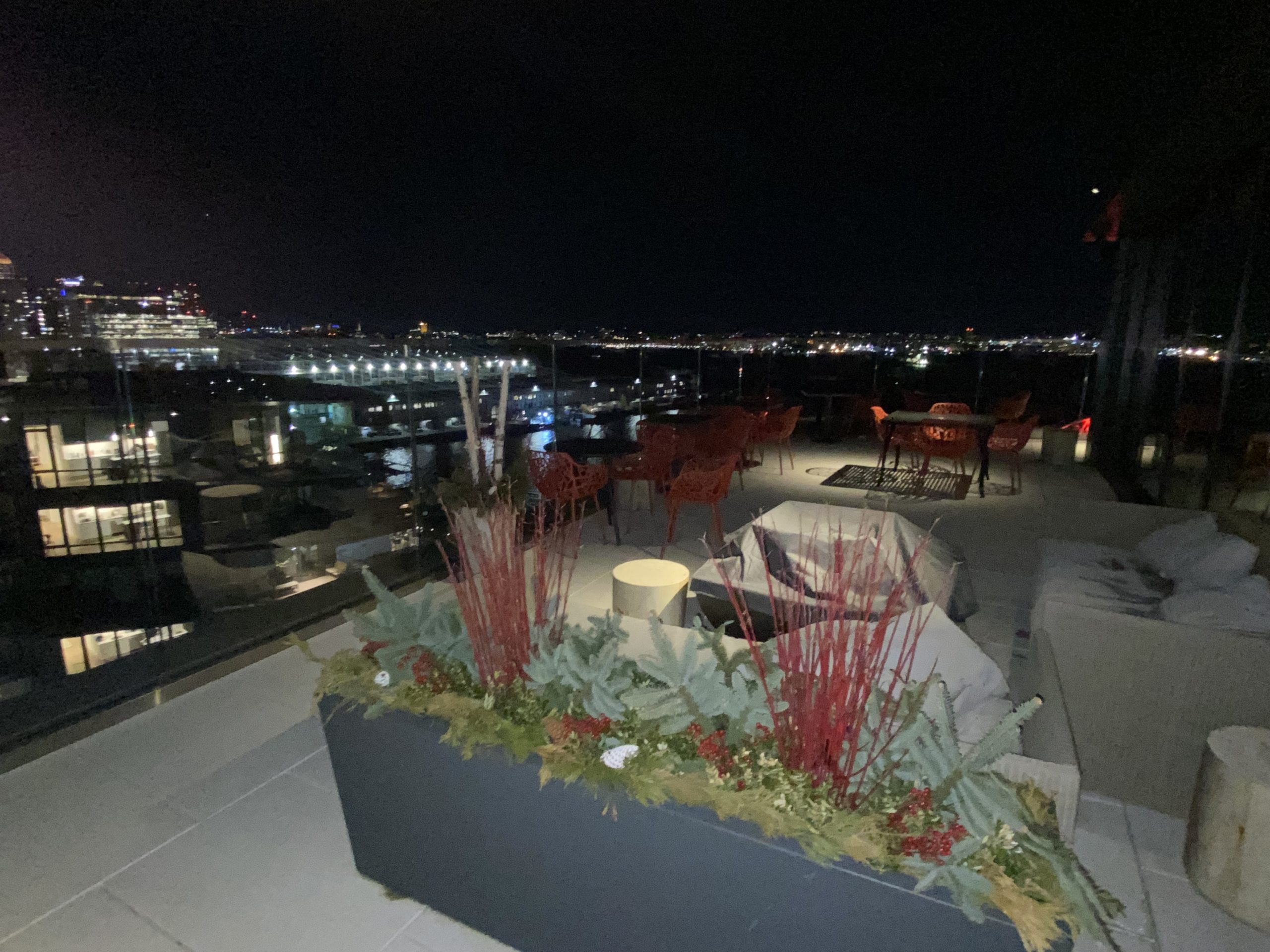 a rooftop patio with a city view at night