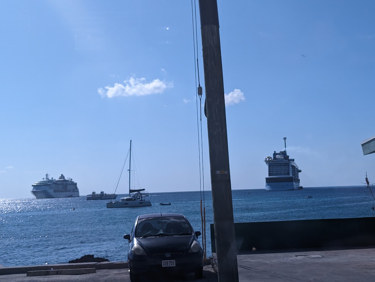 a car parked on a dock next to a large ship