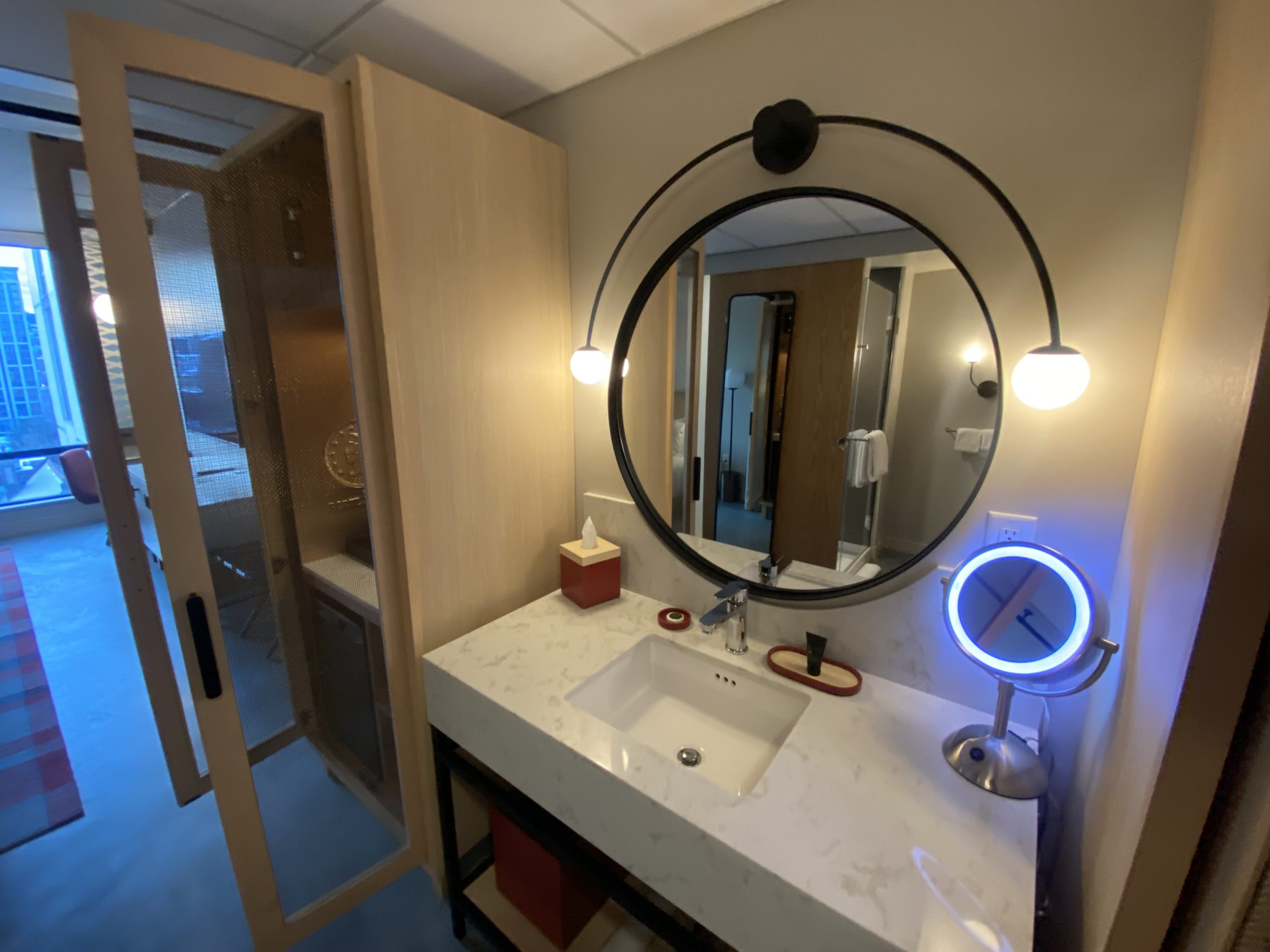 a bathroom with a round mirror and a mirror