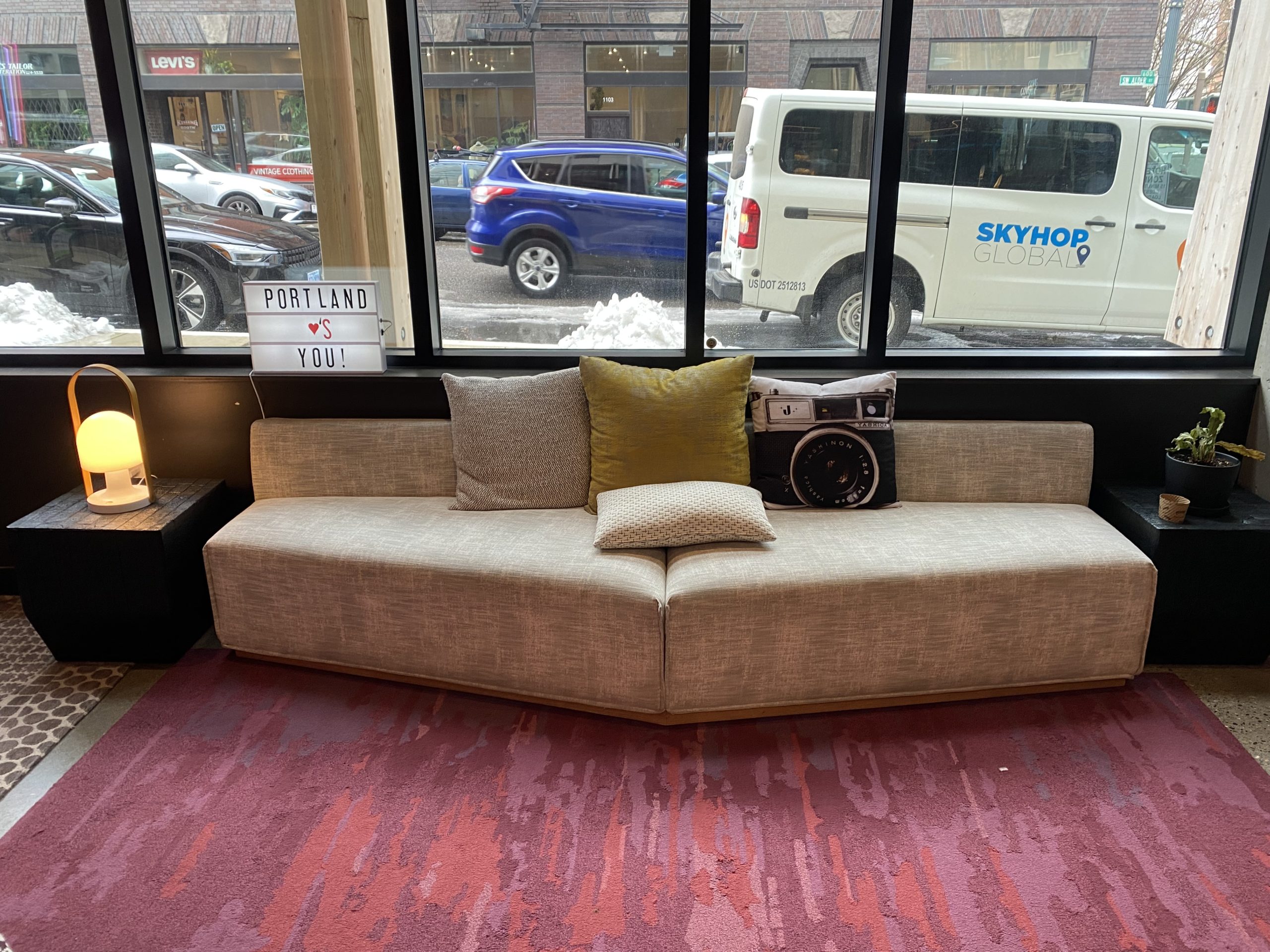 a couch with pillows and a couple of windows