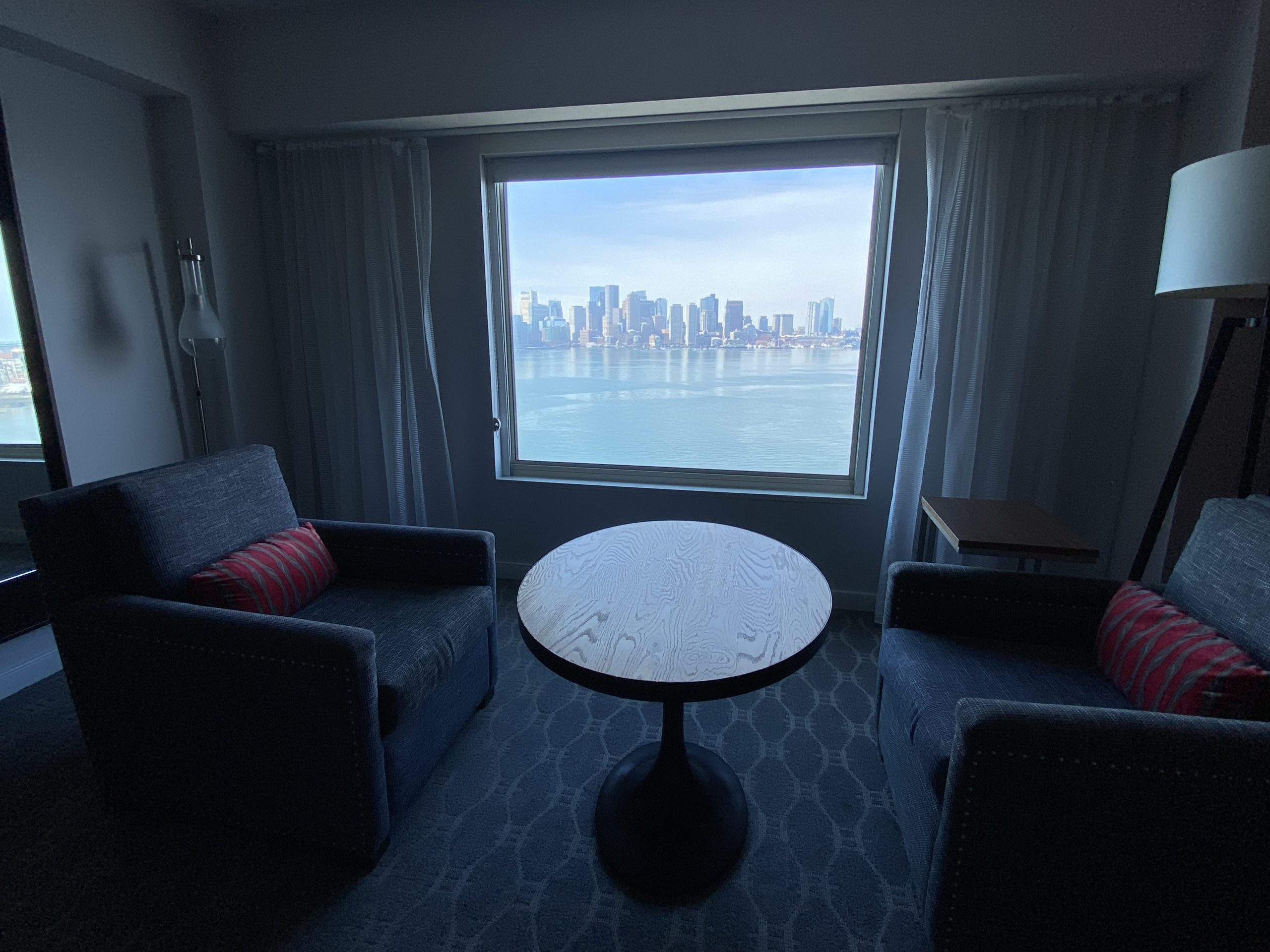 a room with a table and chairs and a window with a city view