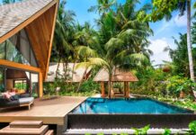 a pool in a house with trees around it