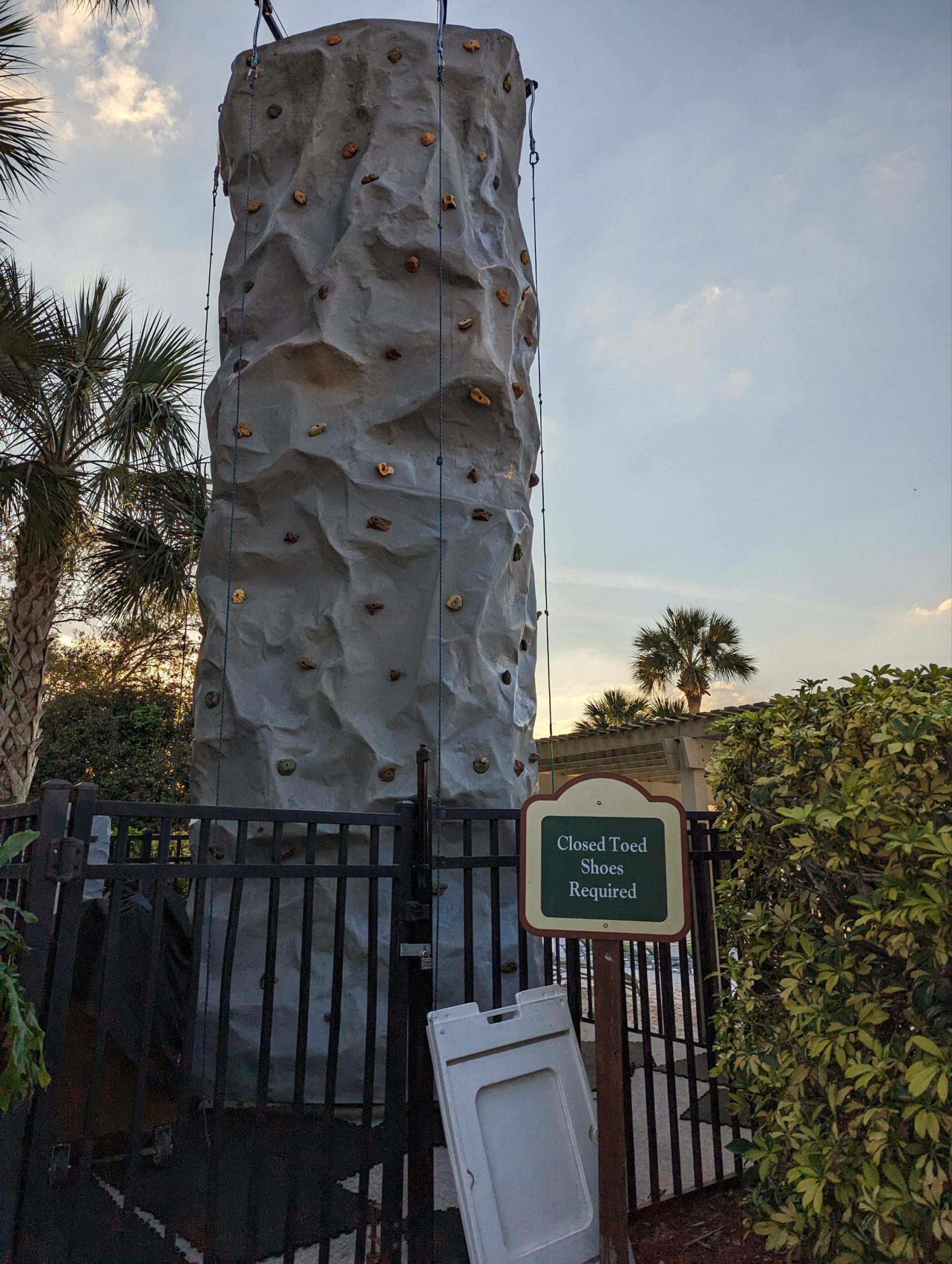 a rock climbing tower in front of a gate