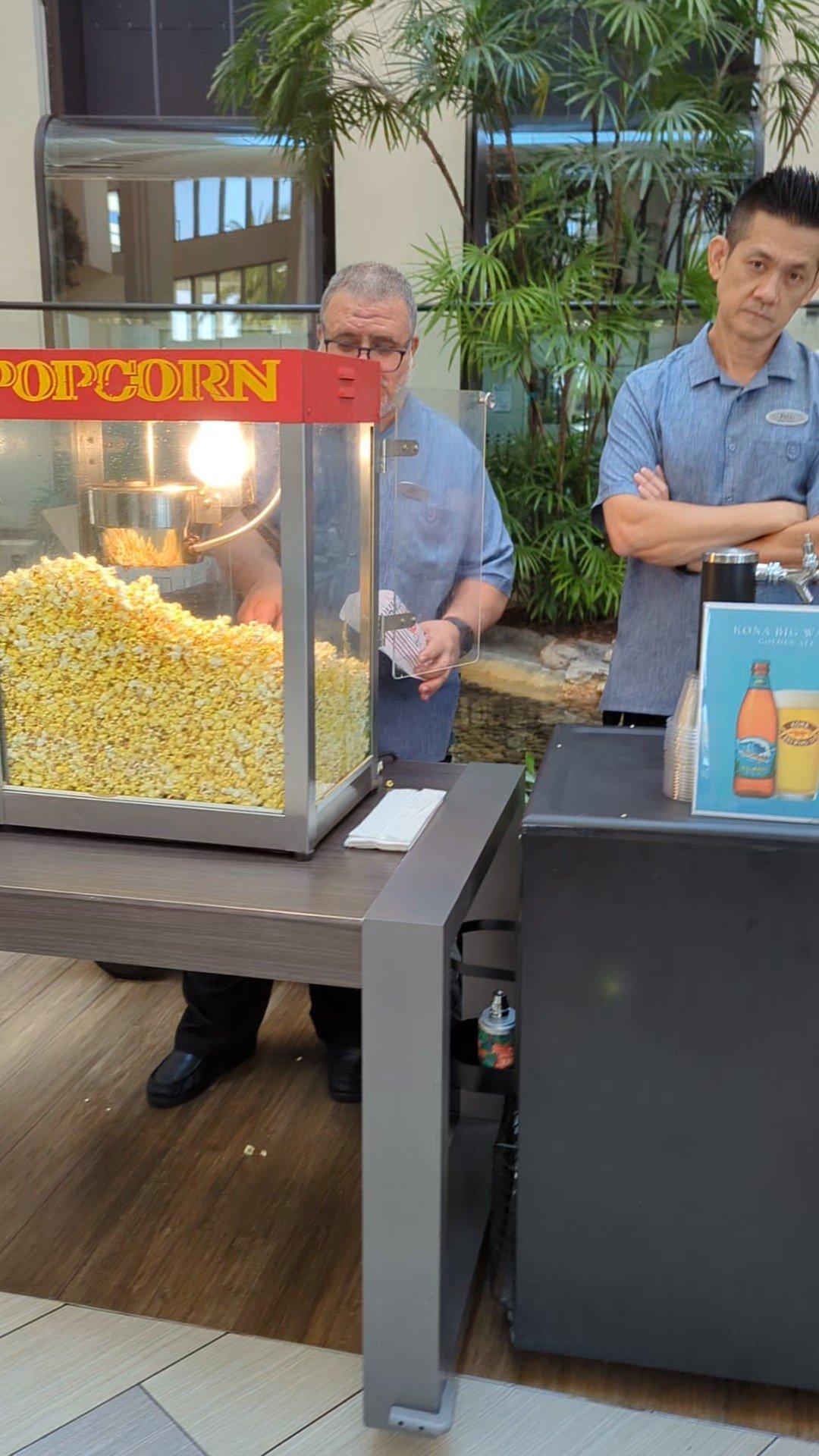 a group of men standing next to a machine with popcorn