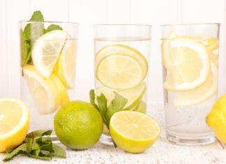 a group of glasses with water and lemons