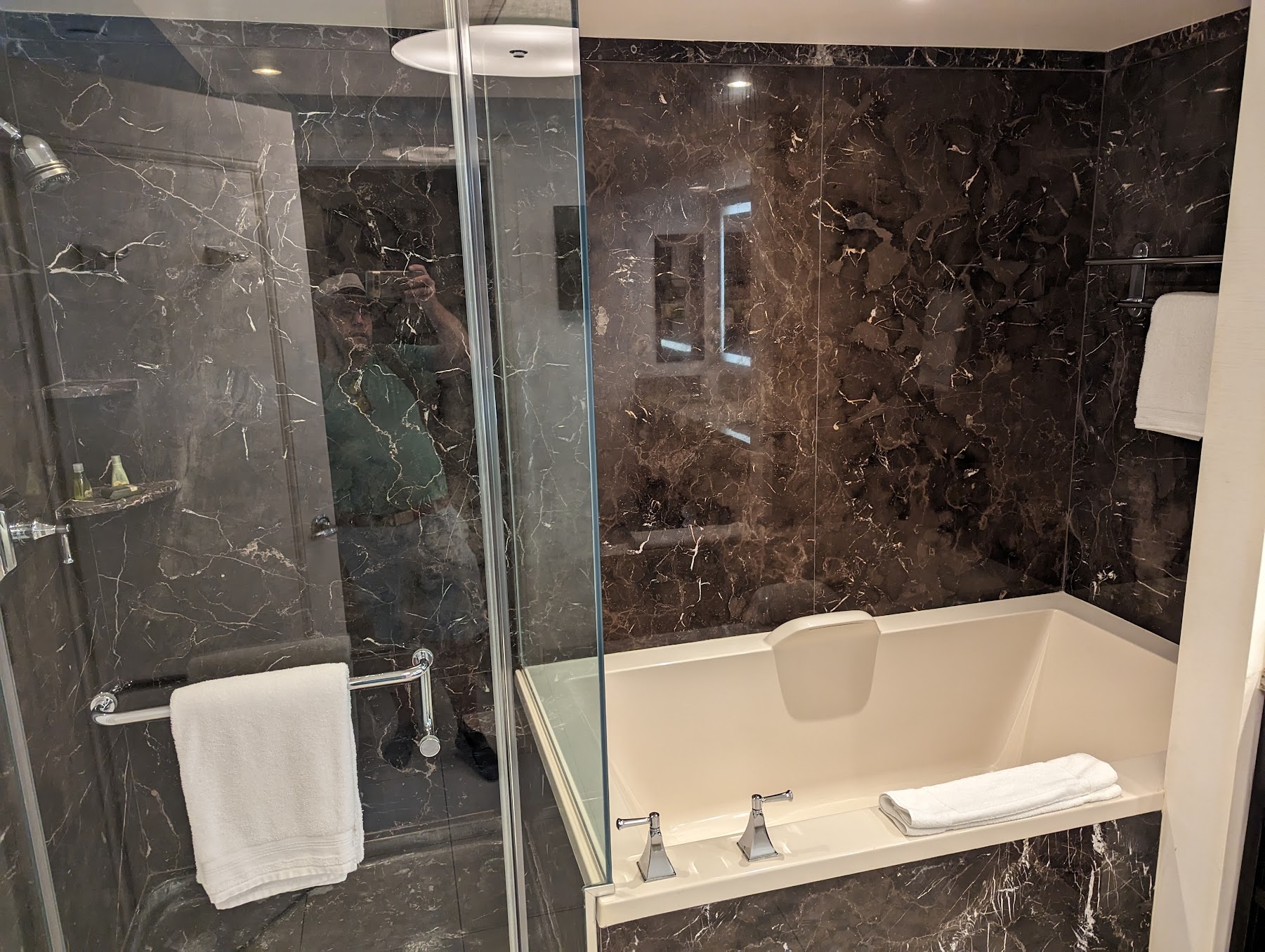 a person taking a picture of a bathtub in a bathroom