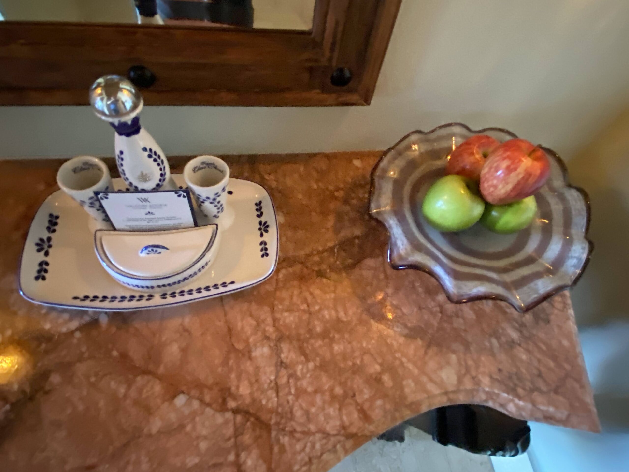 a plate of fruit and a bowl of juice on a marble counter