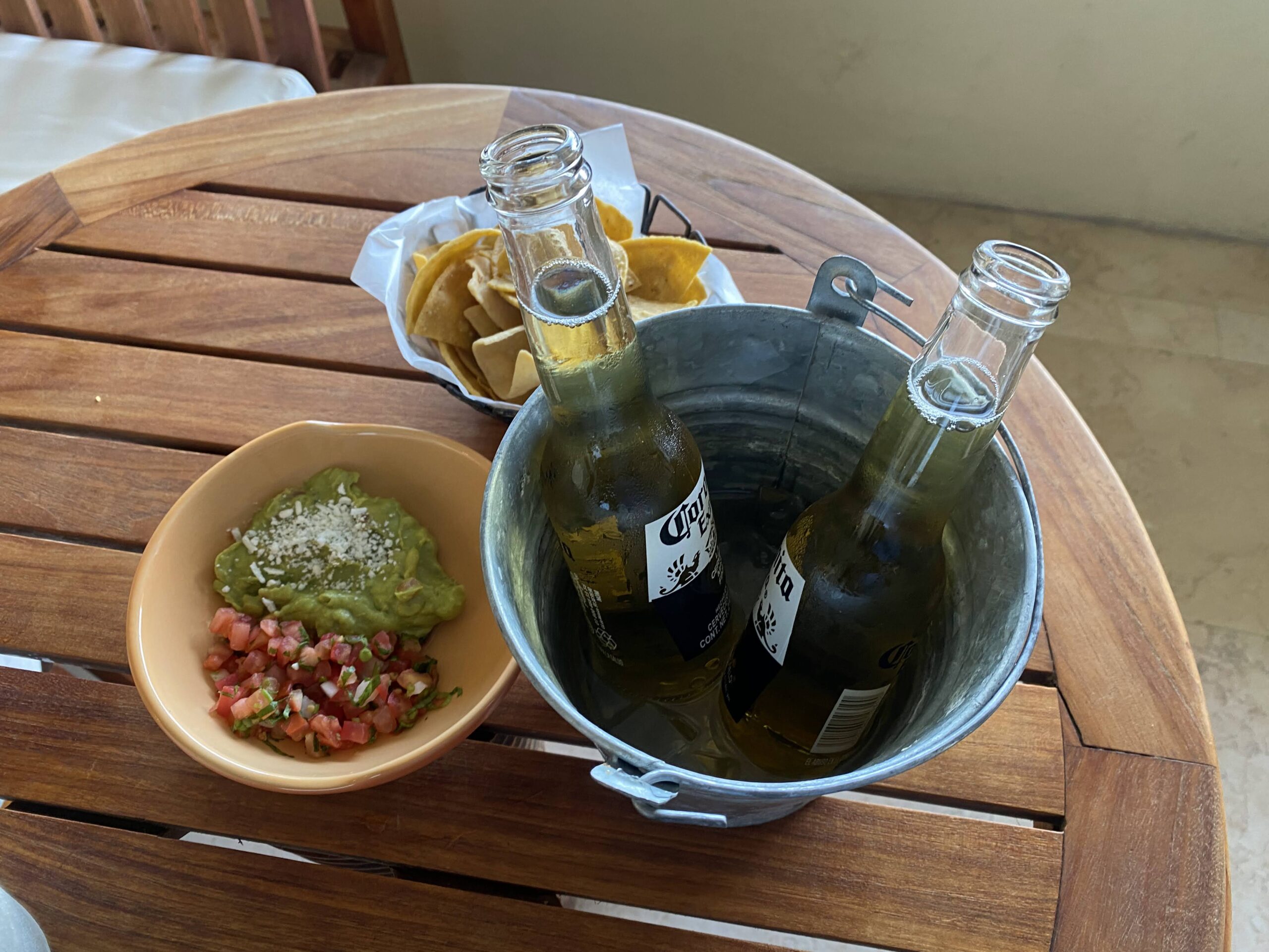 a bucket of beer and a bowl of salsa on a table