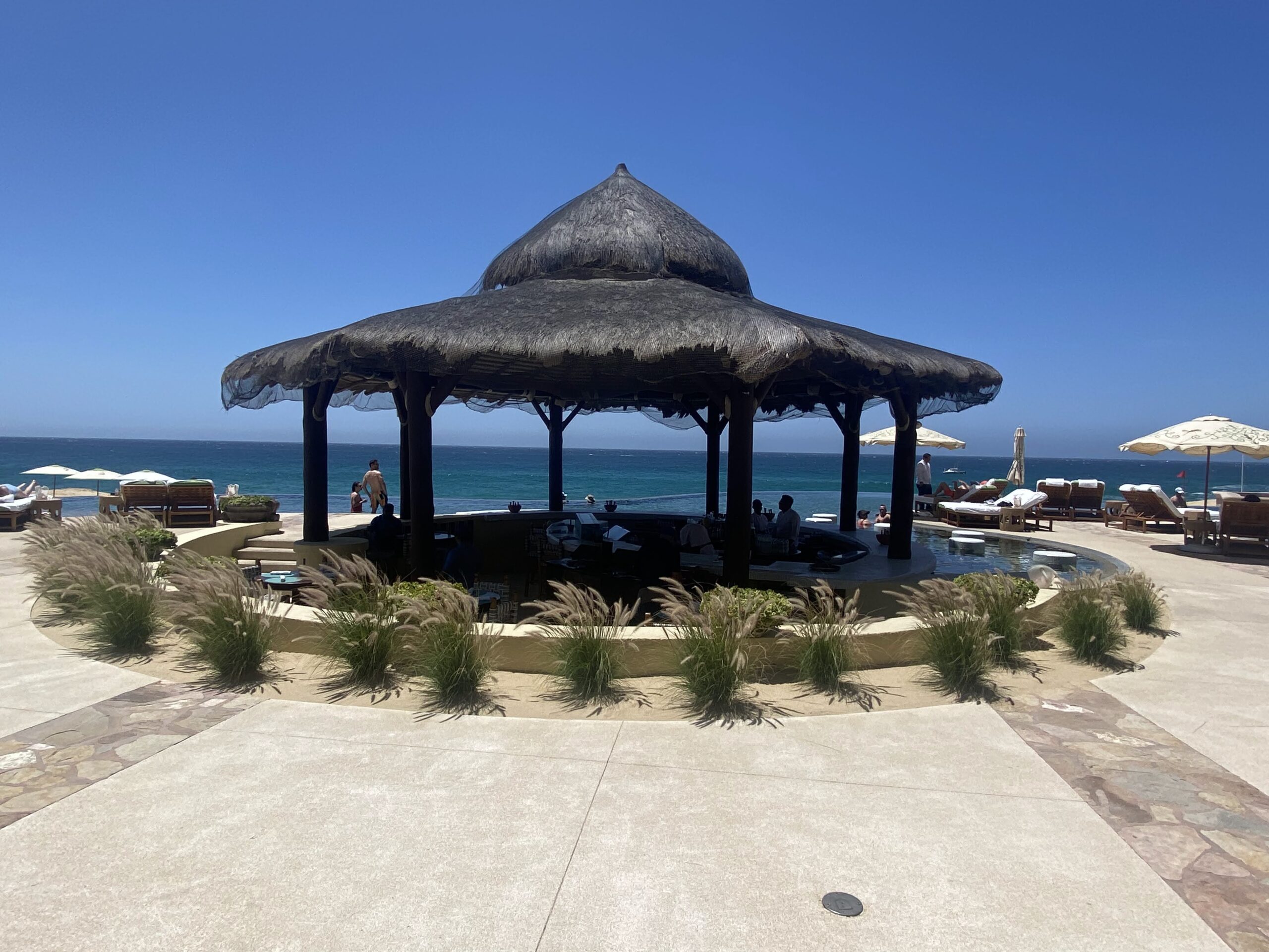 a thatched roof gazebo on a beach