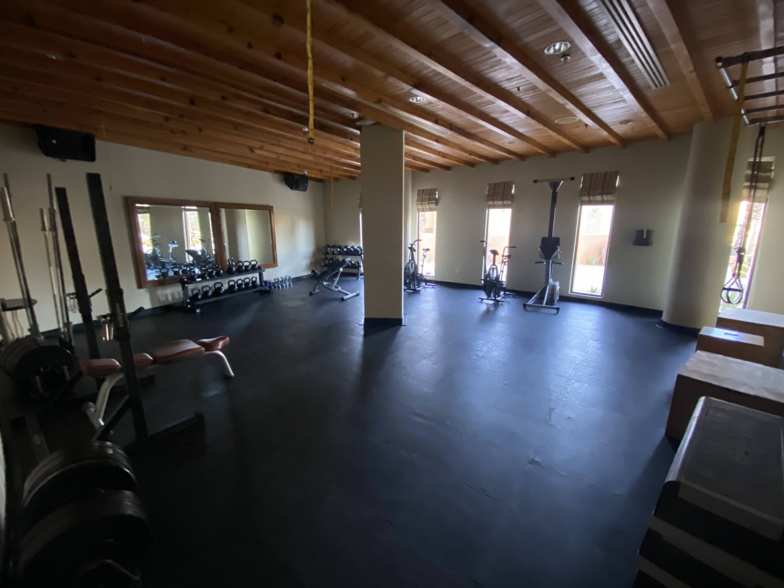 a room with exercise bikes and a wood ceiling