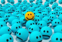 a yellow smiley face in a group of blue balls