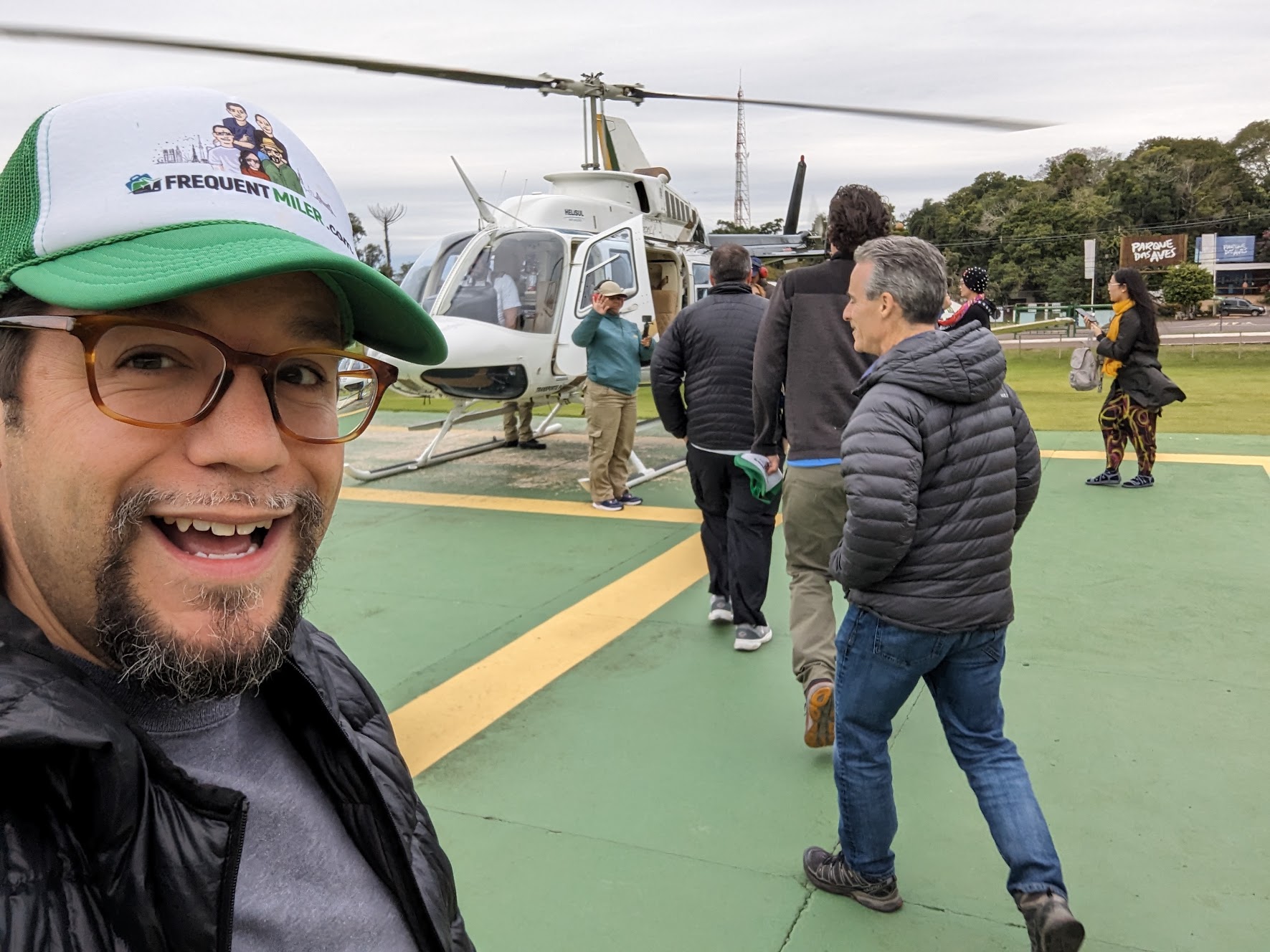 a man taking a selfie with a helicopter in the background