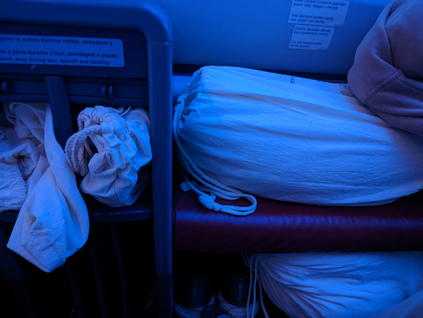 a bed with white sheets and a bag on it
