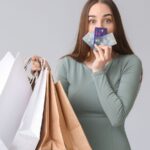 a woman holding shopping bags and a credit card