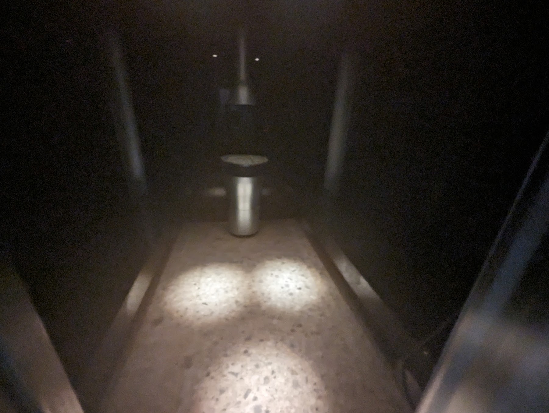 a light shining on a dark hallway