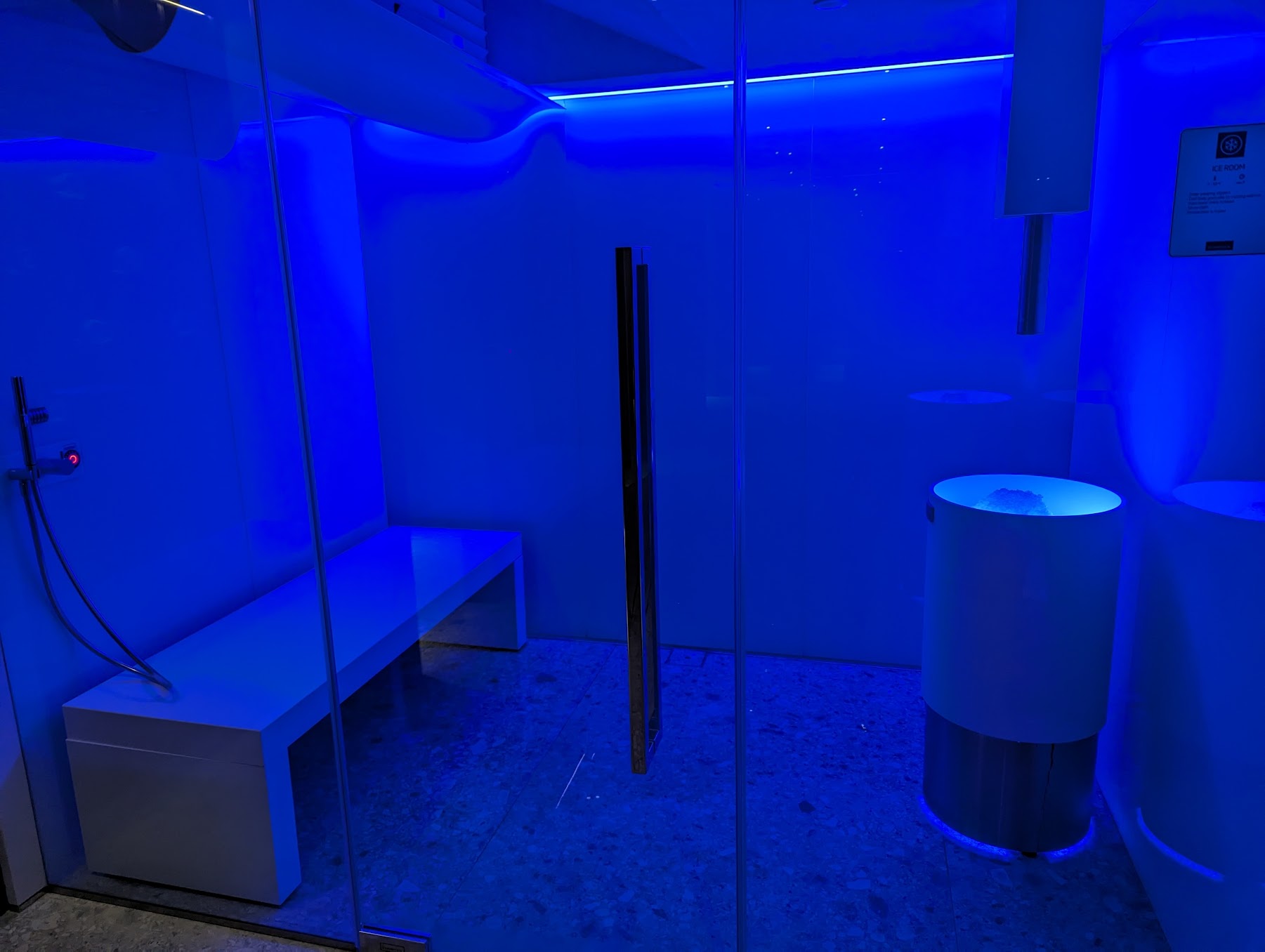 a glass shower with a blue light