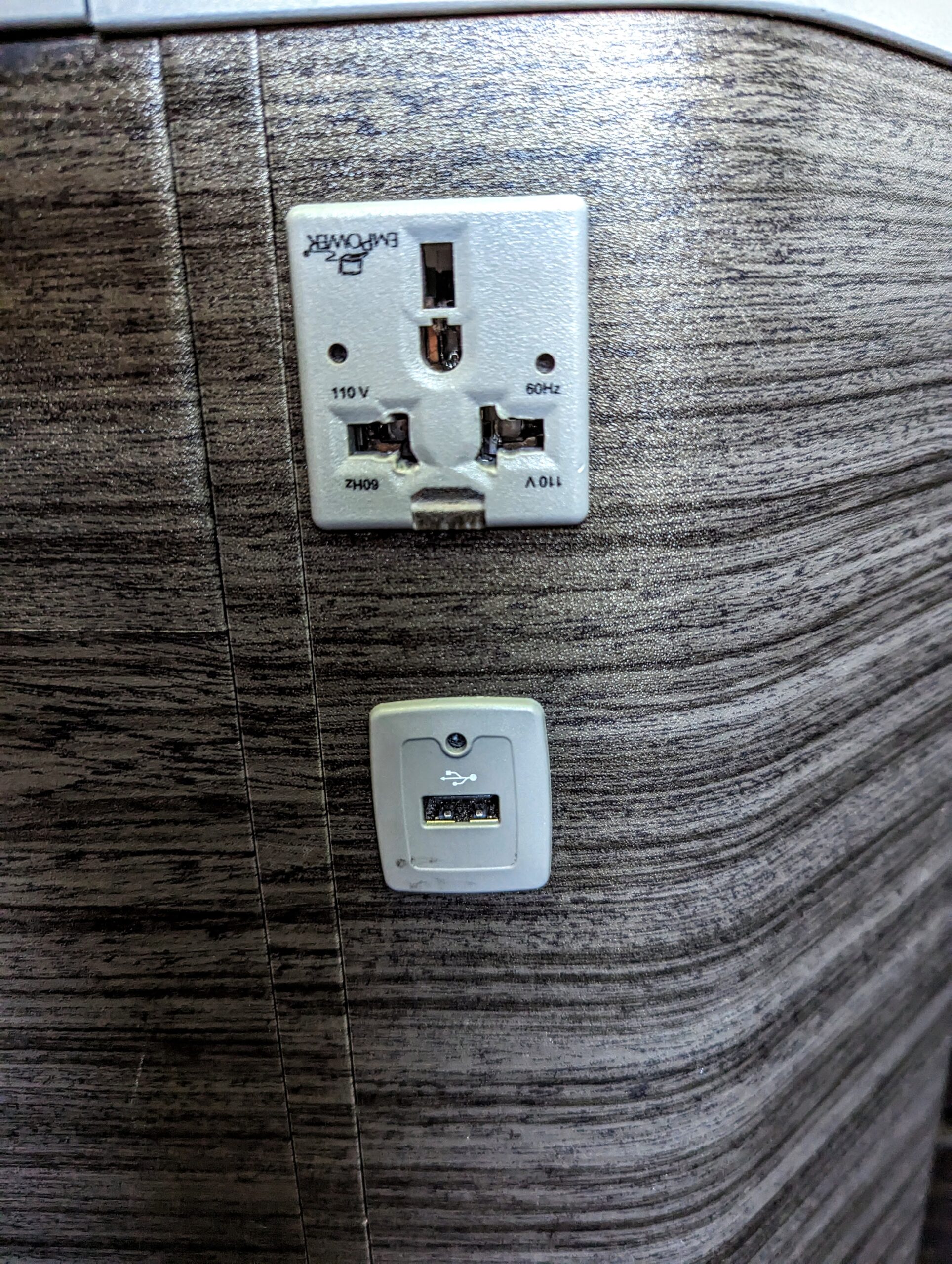 a white outlet and a usb port on a wood wall
