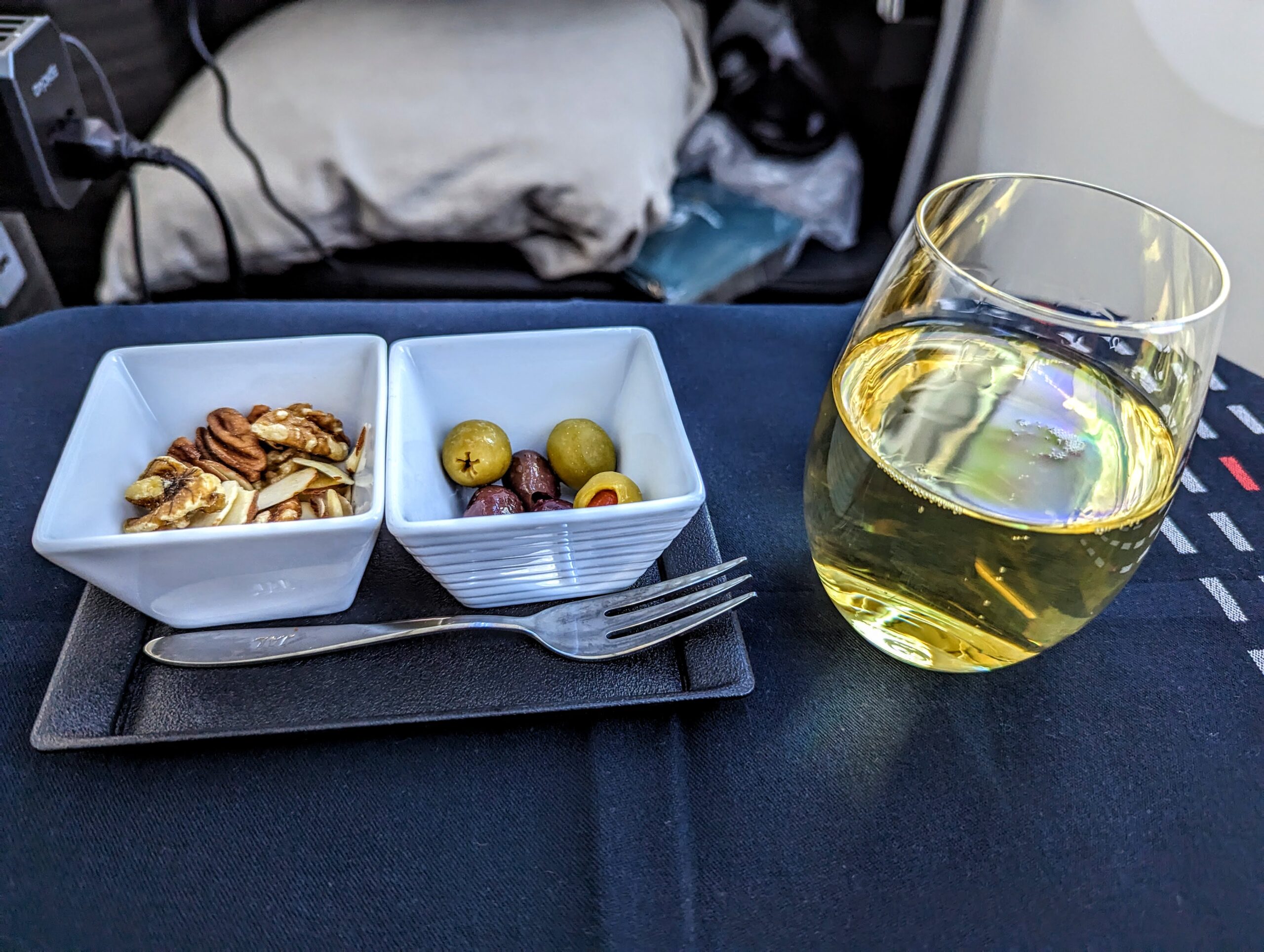 a plate with food in bowls and a glass of wine