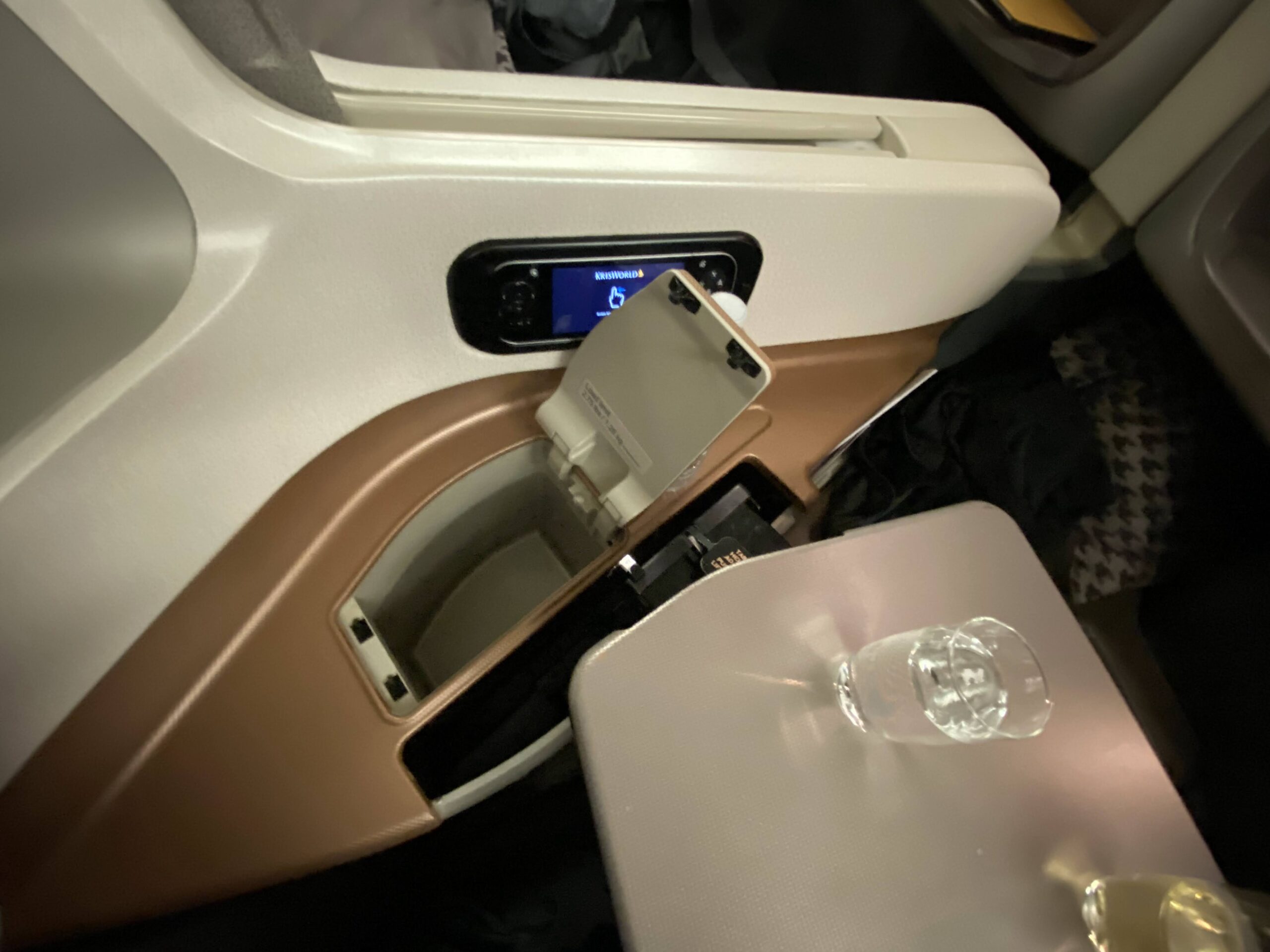 an airplane seat with a drink and a small table