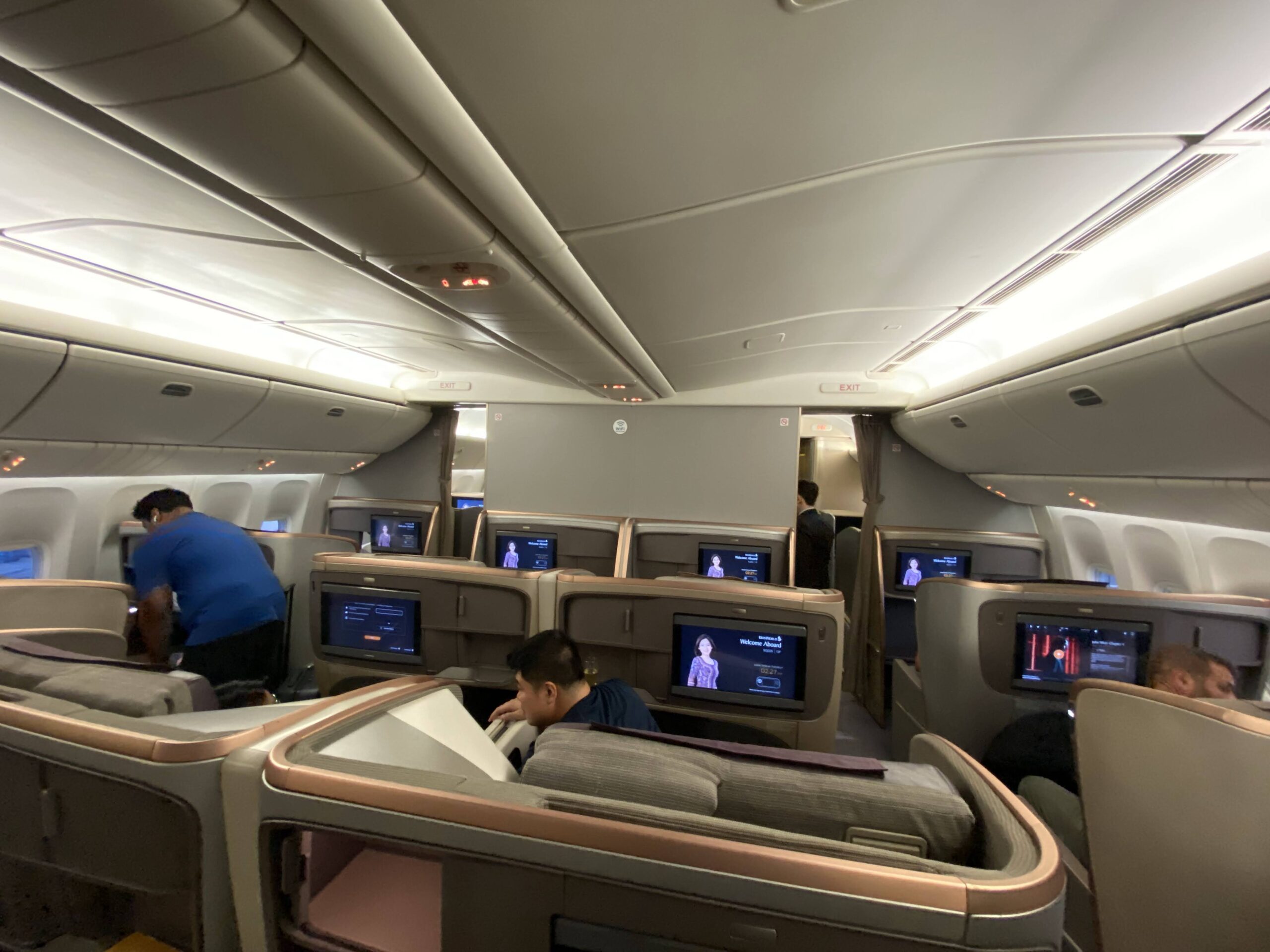 people inside of an airplane with a few people sitting on the seats