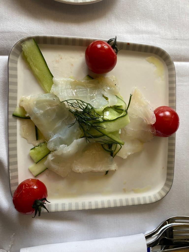a plate of food with tomatoes and cucumbers