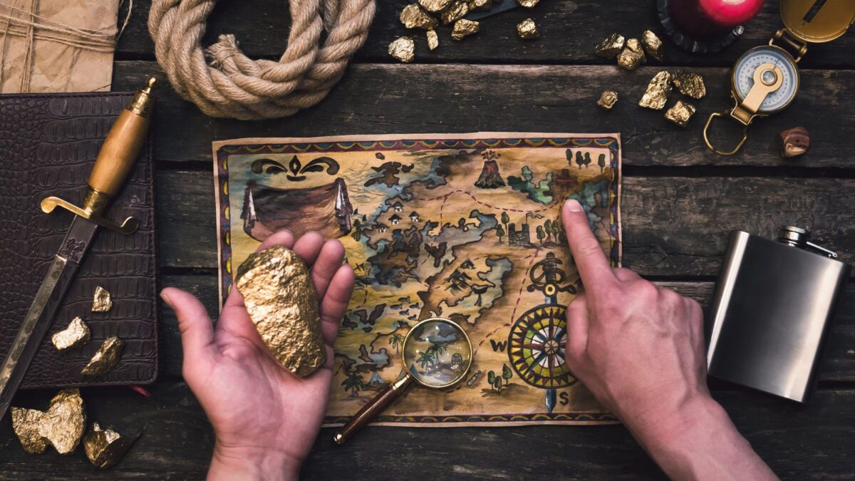 a person holding a gold nugget and a map