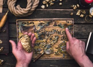 a person holding a gold nugget and a map