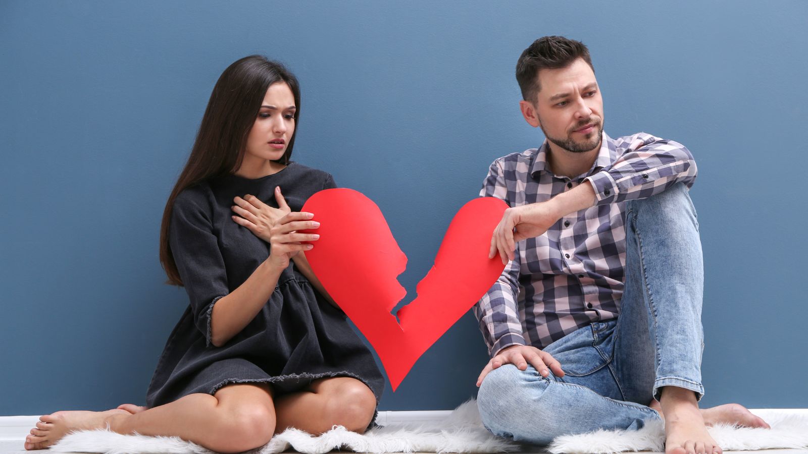 a man and woman holding a broken heart