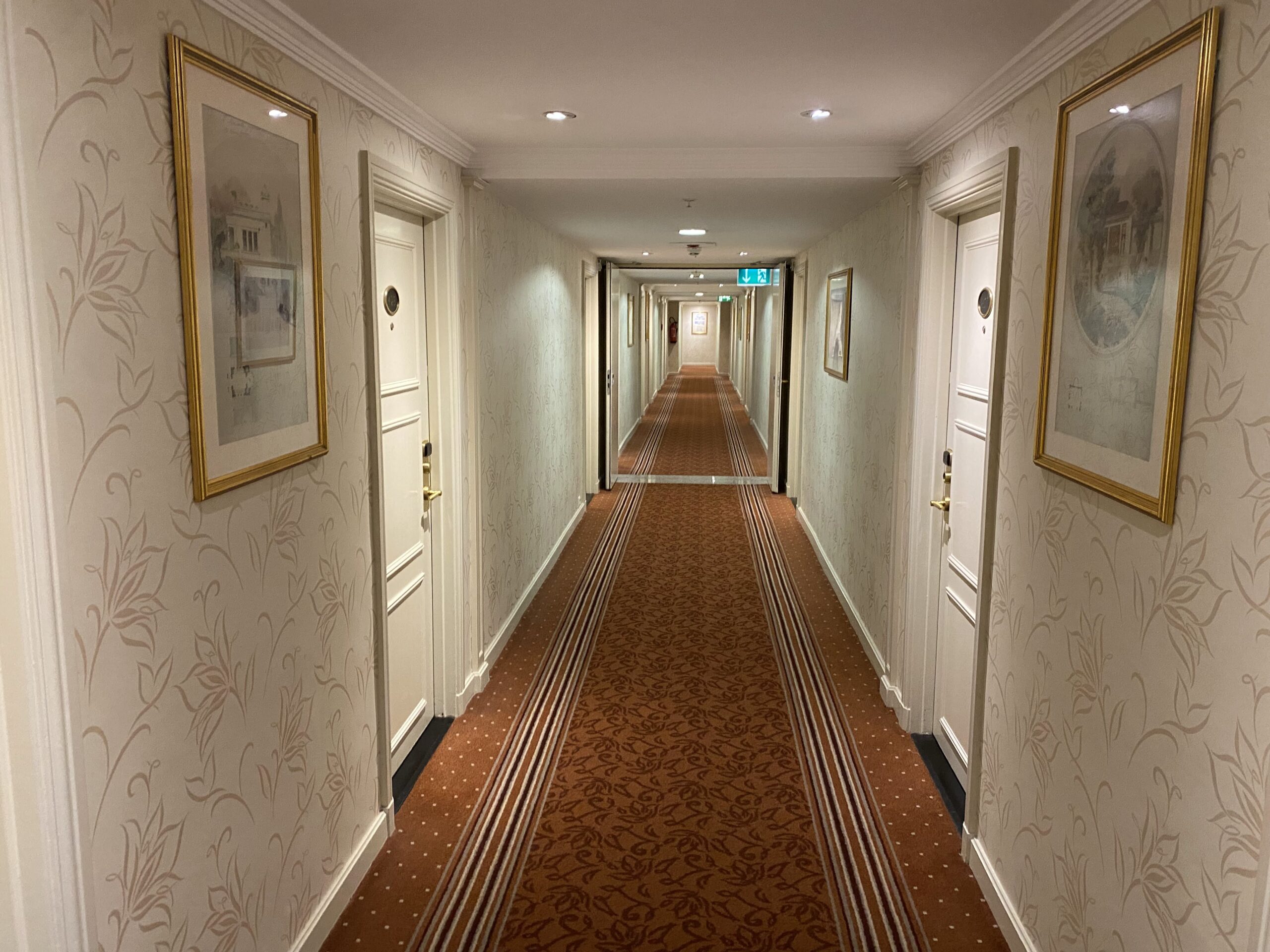 a long hallway with a carpeted floor and doors