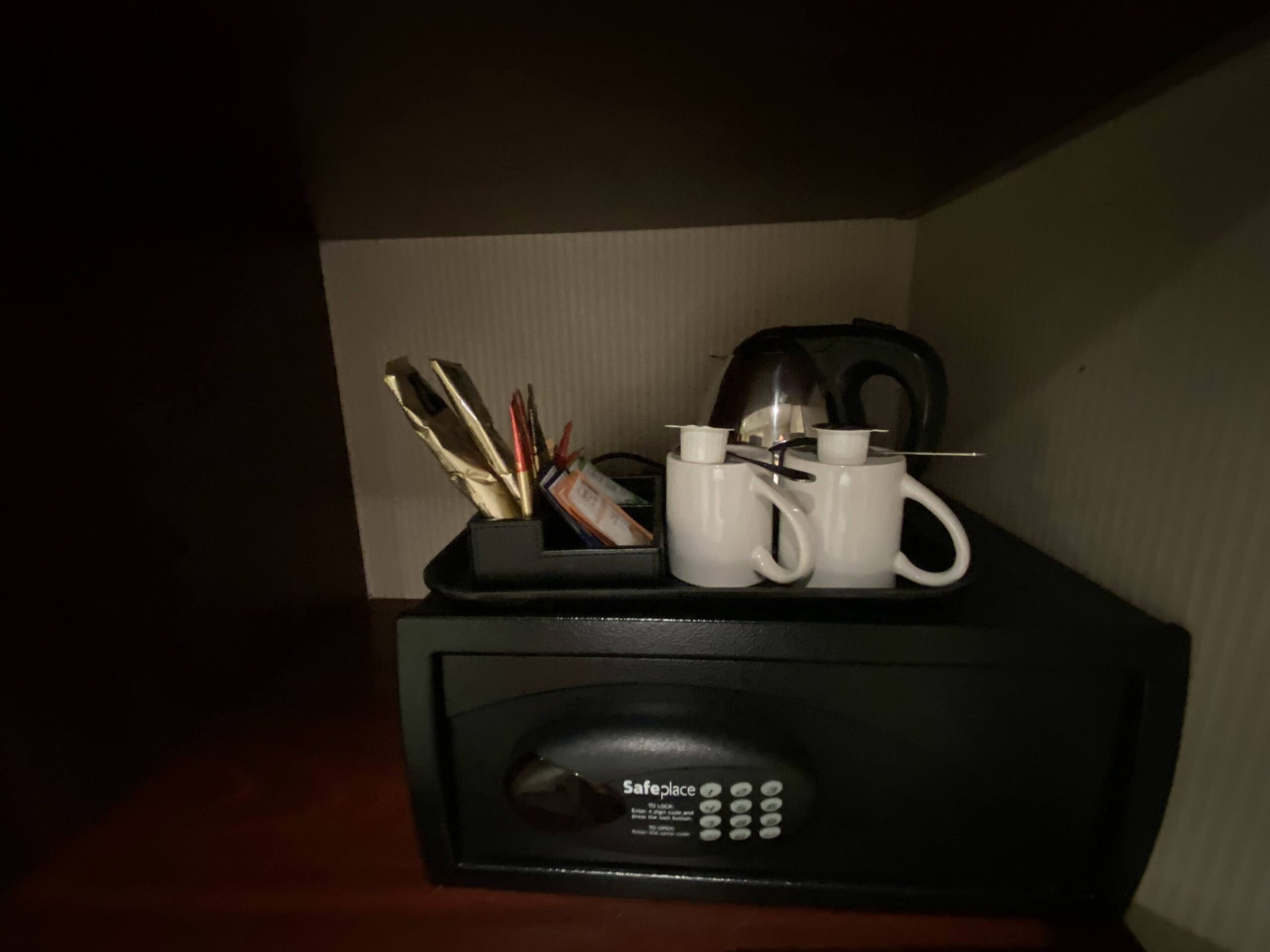 a small black safe with a tray of coffee cups and a teapot