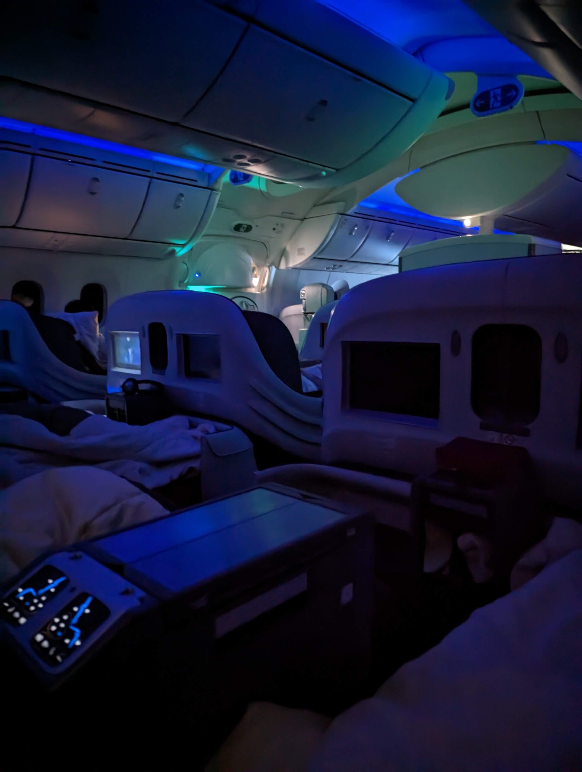 inside a plane with seats and a blue light