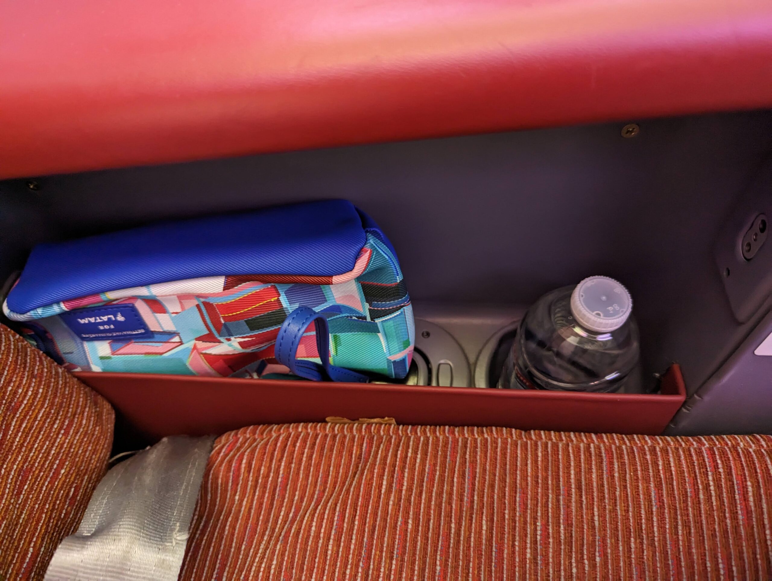 a blue and red bag in a red seat