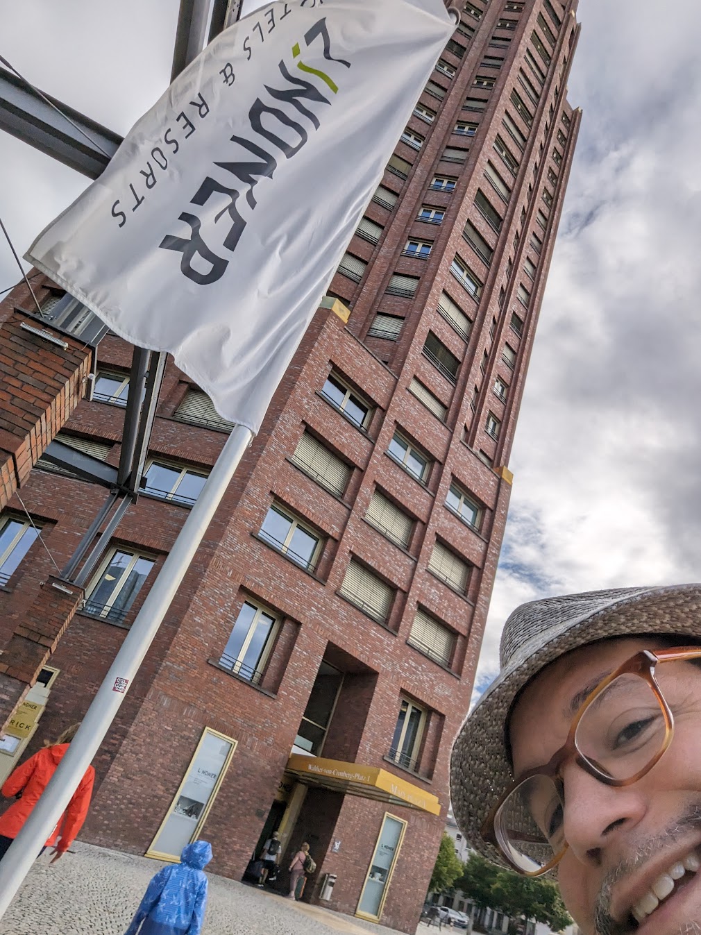 a selfie of a woman in front of a tall building