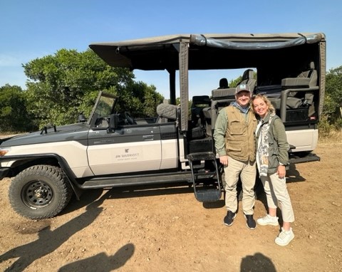 a man and woman standing in front of a jeep
