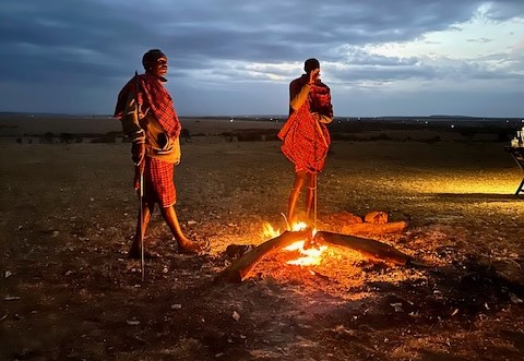 two men standing around a fire