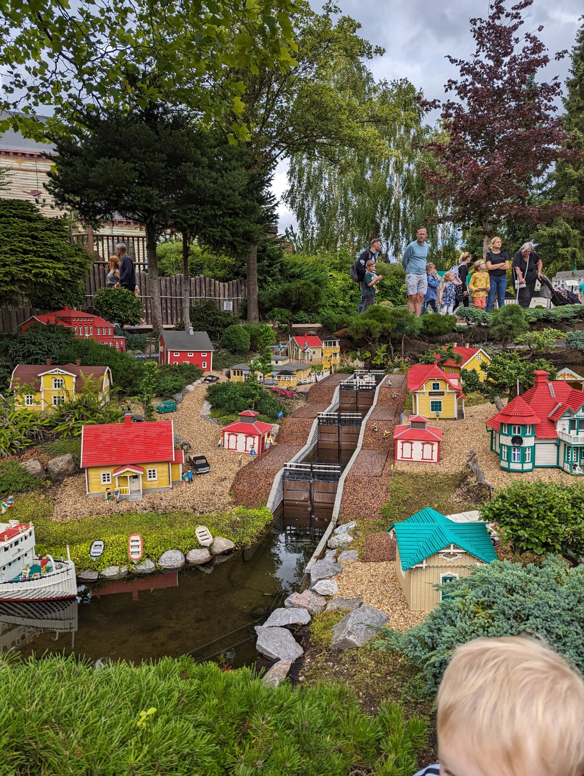a group of people standing around a small model town