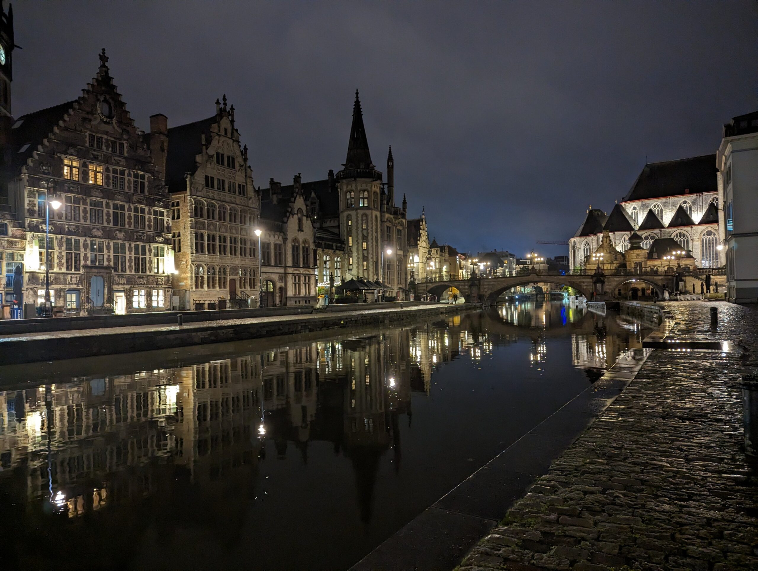 a river with buildings and Ghent at night