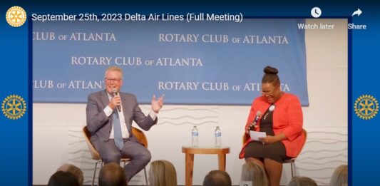 a man and woman sitting in chairs with microphones