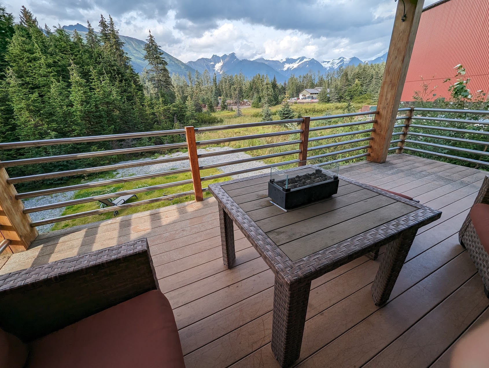 a table and chairs on a deck overlooking a mountain range
