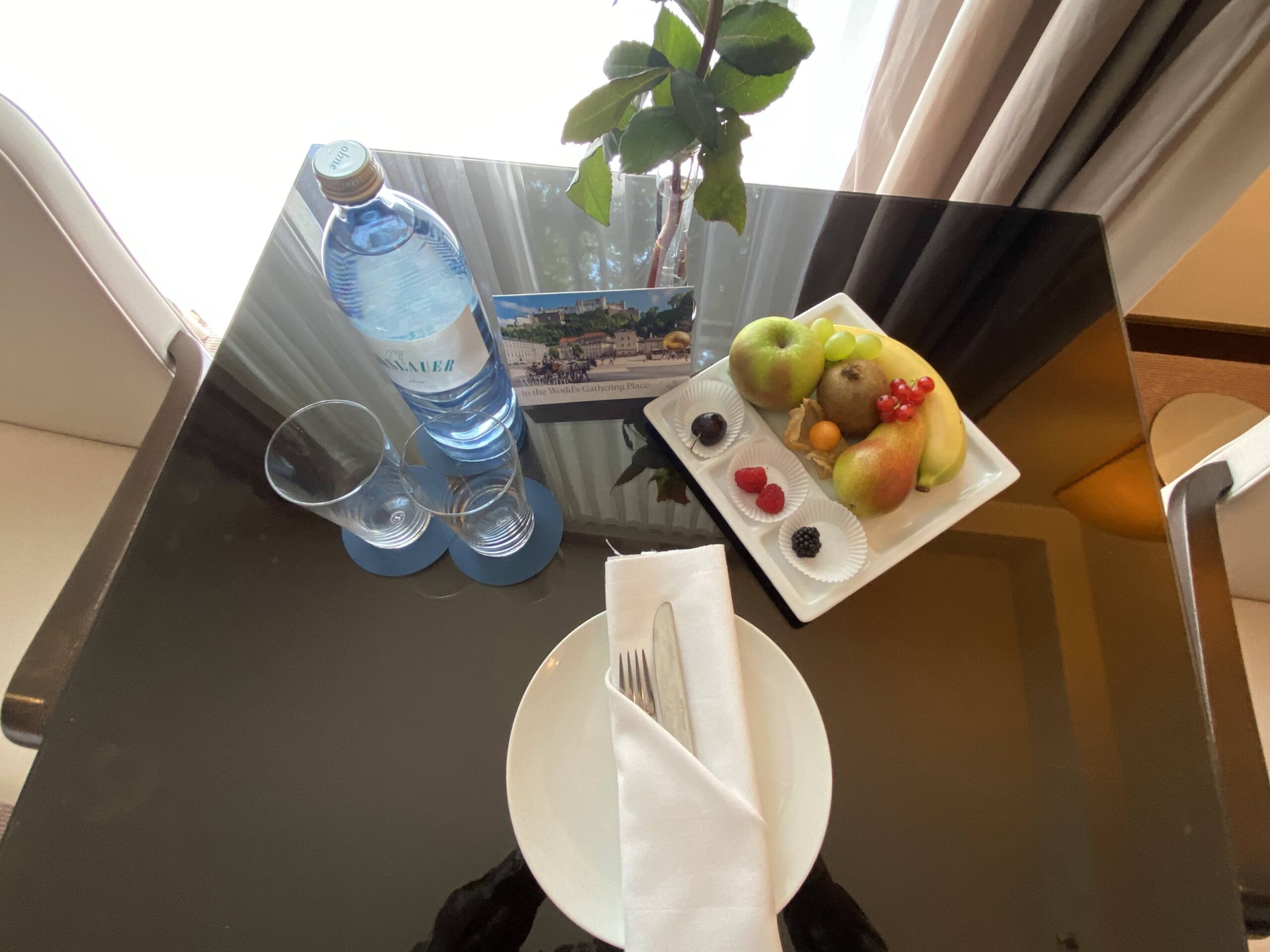 a plate of fruit and a bottle of water on a table